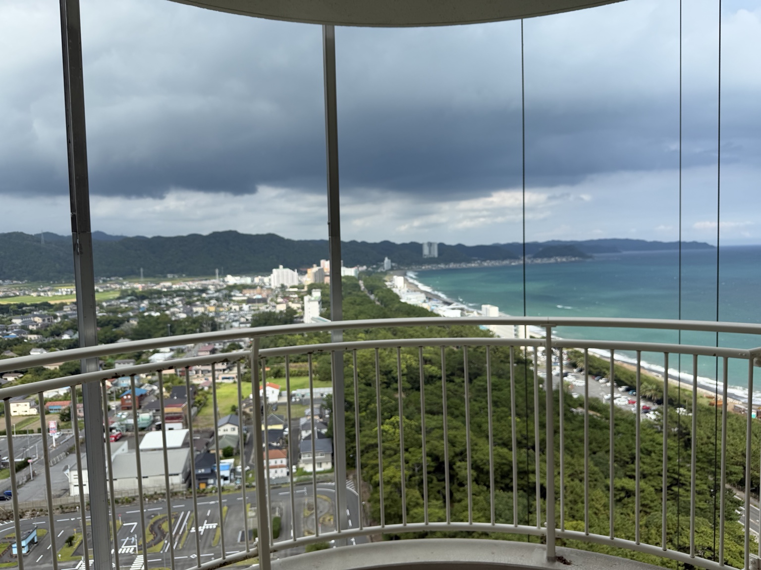 部屋のベランダから眺める雲の広がった鴨川の海